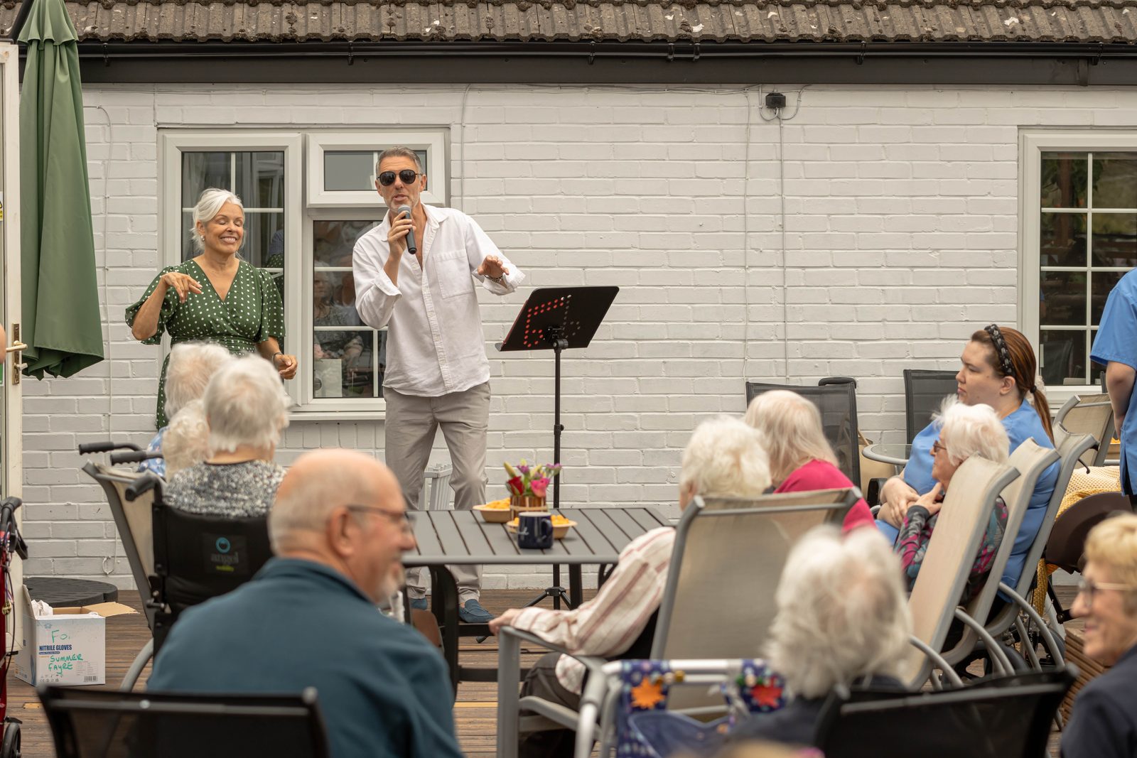 A singer performing for residents on the decking