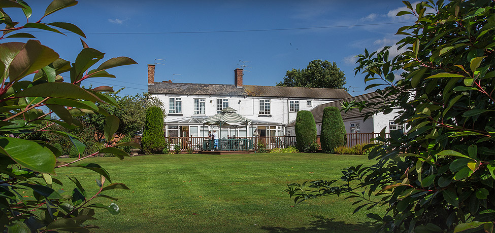 Wispington House seen across its lawn on a summer afternoon