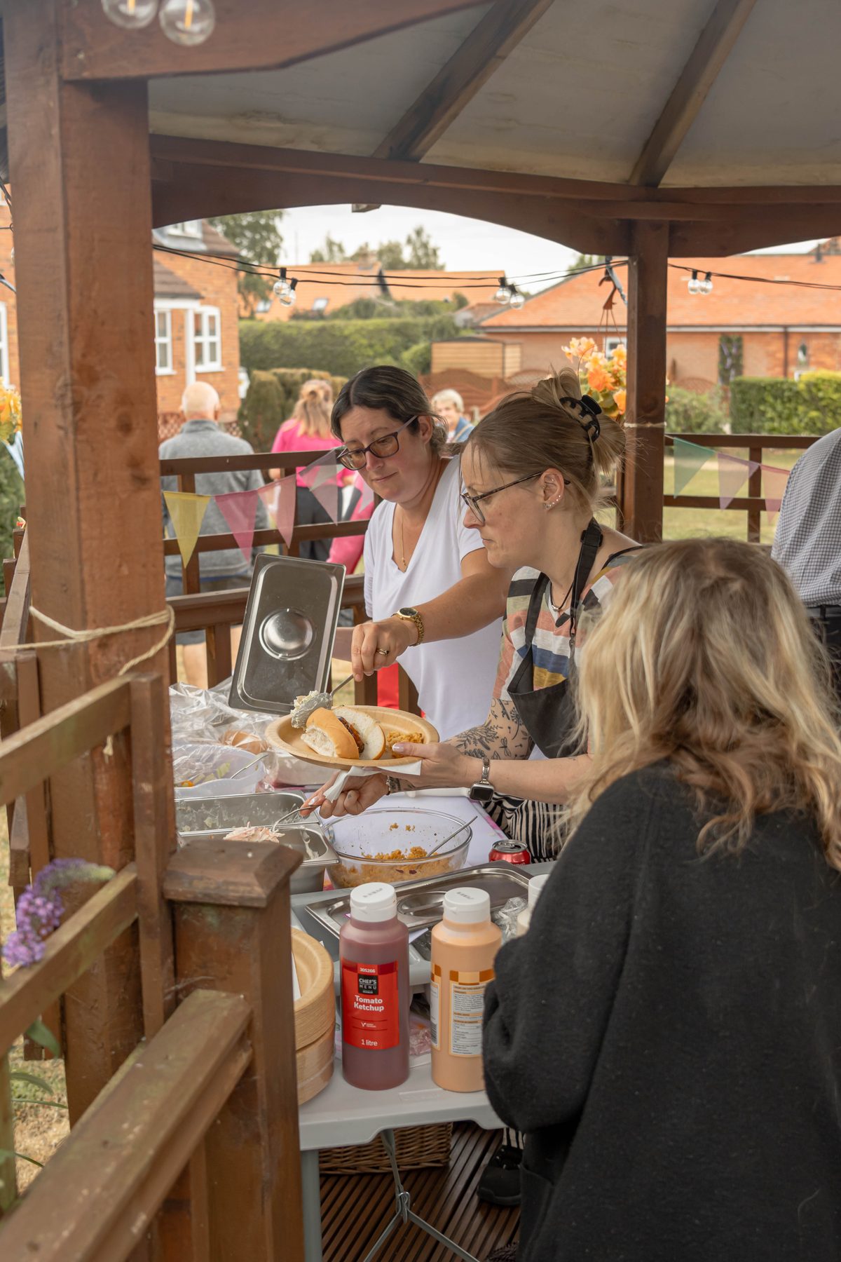 Two members of the Wispington House team serving food at the summer fayre